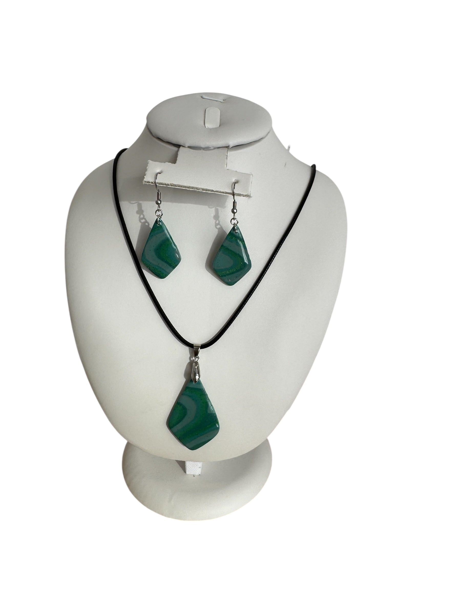 Jewelry set with necklace and earrings on a mannequin bust against a white background